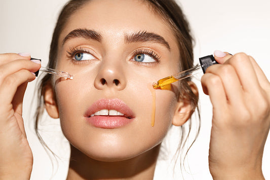 Woman holding a skincare dropper near her face